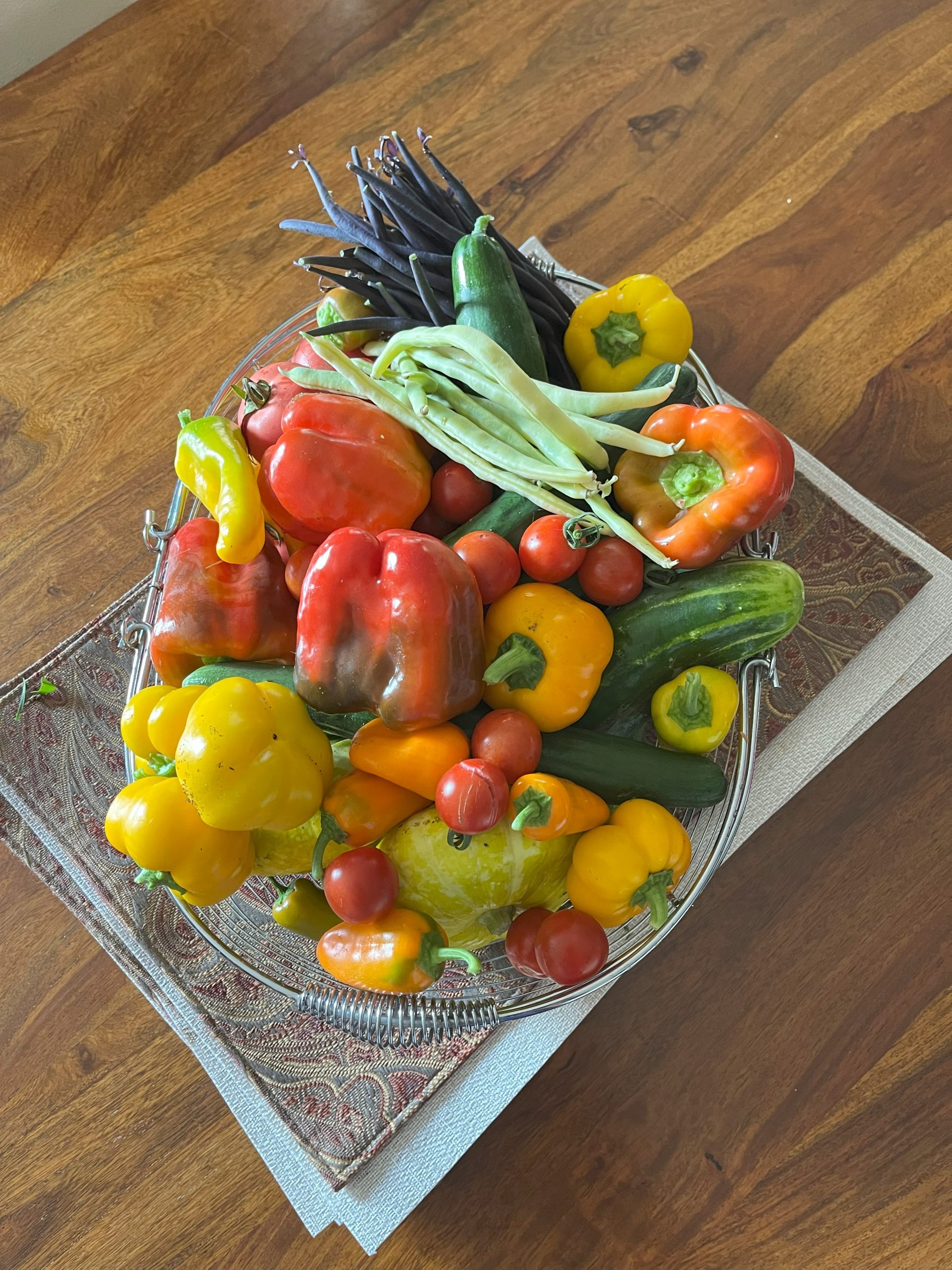 A basket of fresh peppers, beans and cucumbers harvested at Thunder Gardens